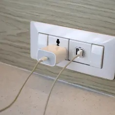 Ładowarka podłączona do gniazdka z portem USB. Pokazuje, jak prawidłowo podłączyć wtyczkę, aby naładować urządzenie.