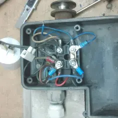 Schemat połączeń silnika elektrycznego z kondensatorem rozruchowym. Widać przewody, zaciski i kondensator.