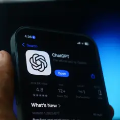 Dłoń trzyma smartfon z ekranem pokazującym aplikację ChatGPT. Zastanawiasz się, jak usunąć AI z telefonu?