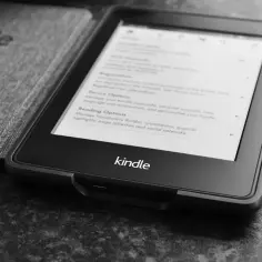 Kindle z otwartym etui, na ekranie widoczne menu ustawień.
