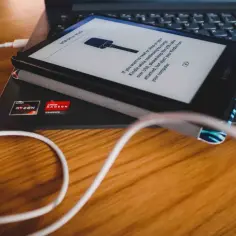 Kindle podłączony do laptopa kablem USB, wyświetla komunikat o trybie dysku.