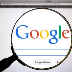 Lupa powiększa logo Google. Szukasz odpowiedzi na pytanie "co to za piosenka google"?
