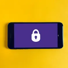 Smartfon z ikoną kłódki na fioletowym tle, symbolizującą wzory blokady telefonu i bezpieczeństwo danych.
