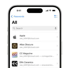 Ekran iPhone'a z listą zapisanych haseł do różnych aplikacji, w tym Apple i Atlas Obscura.