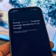 Dłoń trzyma smartfon z ekranem wyświetlającym komunikat o asystencie AI Gemini od Google.