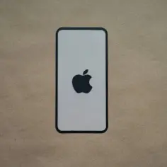 Ikona Apple na tle przypominającym papier. Dowiedz się, jak usunąć konto Apple ID.