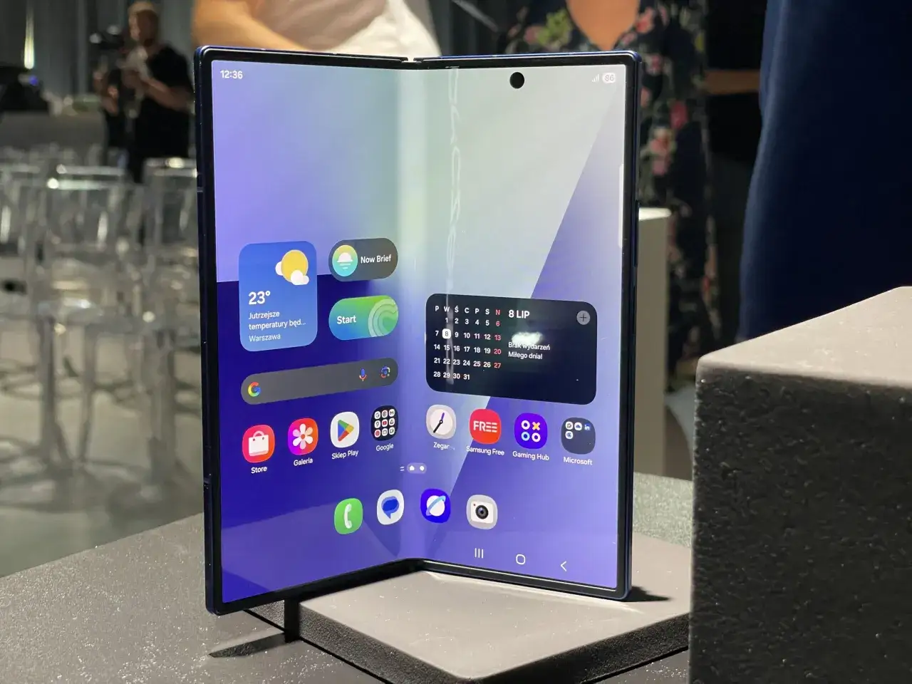 Składany smartfon z dużym ekranem, który wygląda jak największy telefon na świecie. Widoczne ikony aplikacji i widżety.