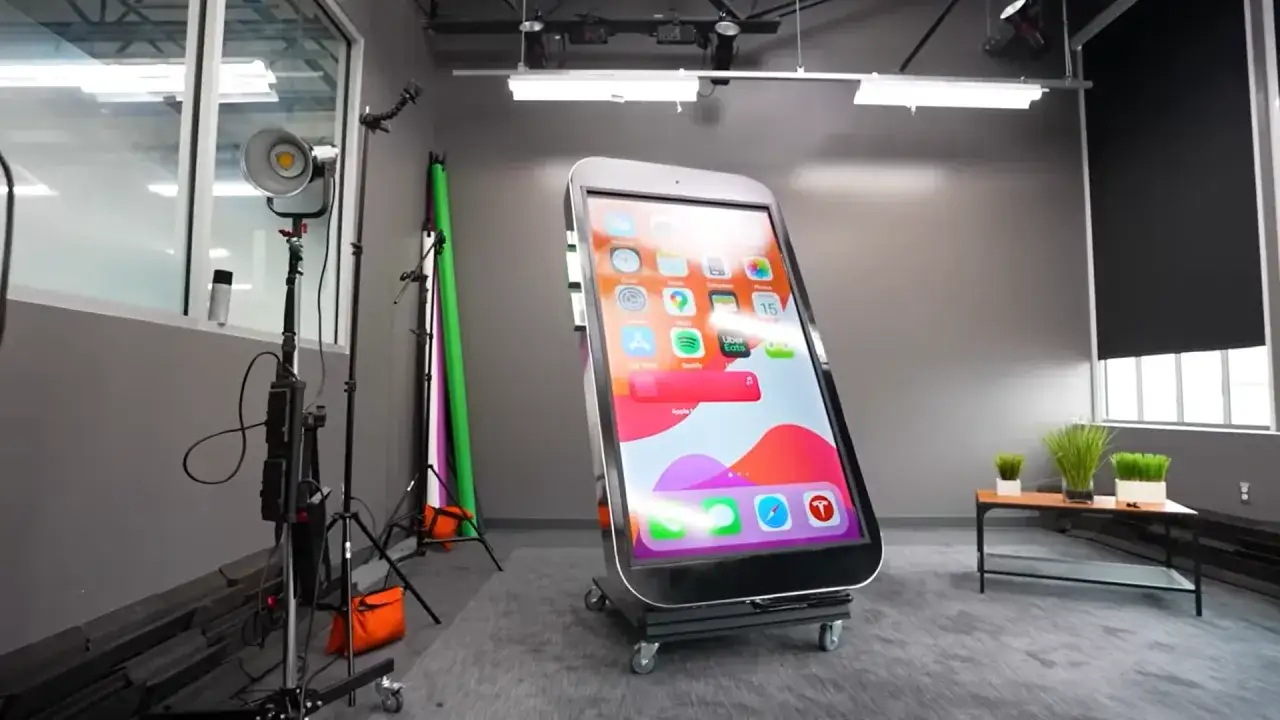 Gigantyczny telefon na kółkach, największy telefon na świecie, stoi w studiu.